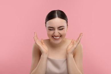 Photo of Portrait of beautiful woman laughing on pink background