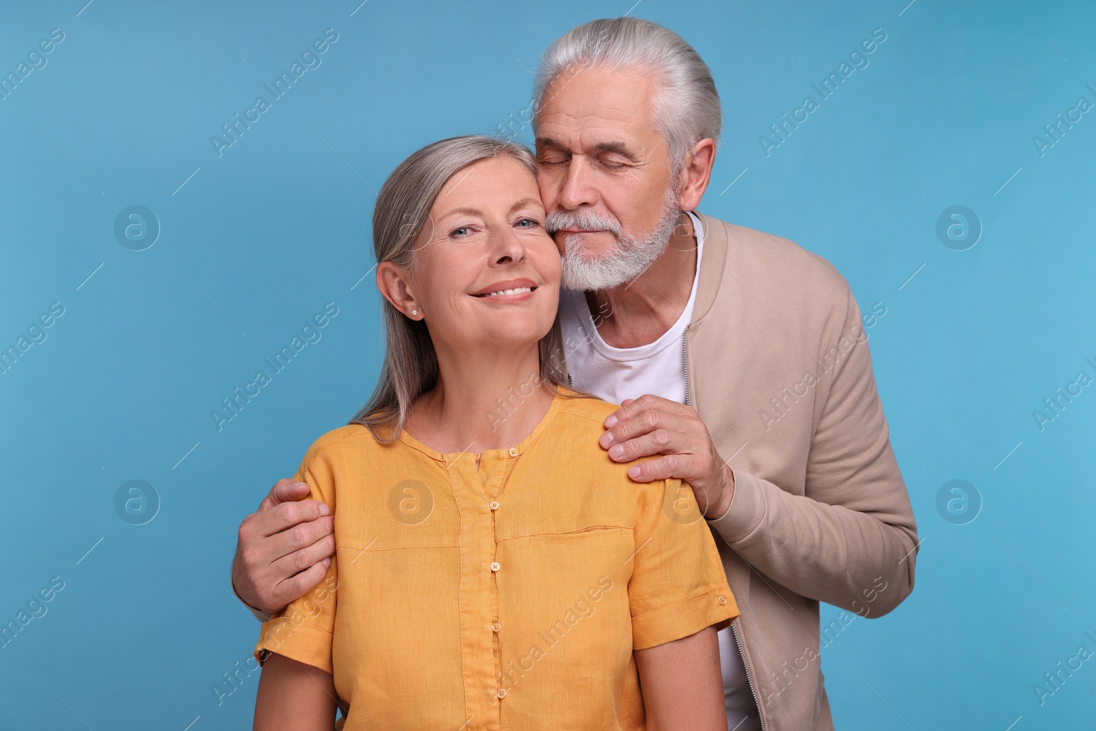 Photo of Portrait of affectionate senior couple on light blue background