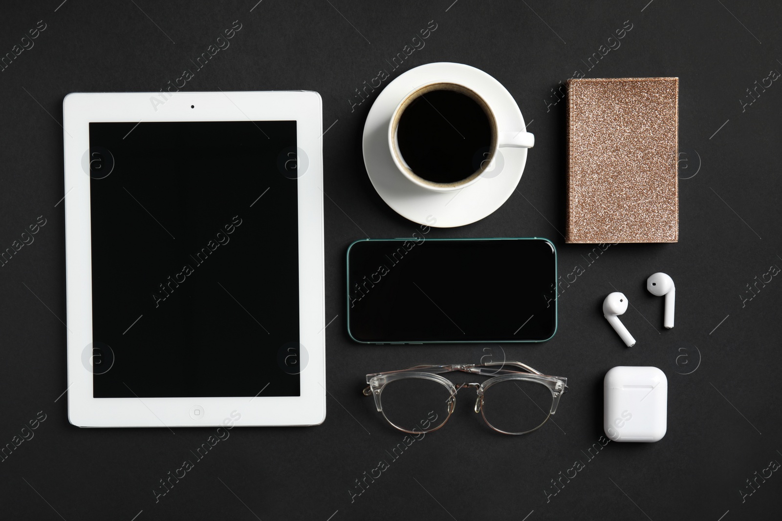 Photo of MYKOLAIV, UKRAINE - JULY 9, 2020: Flat lay composition with Iphone 11, IPad tablet and AirPods on black background, flat lay