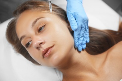 Photo of Beautiful woman getting facial injection in salon