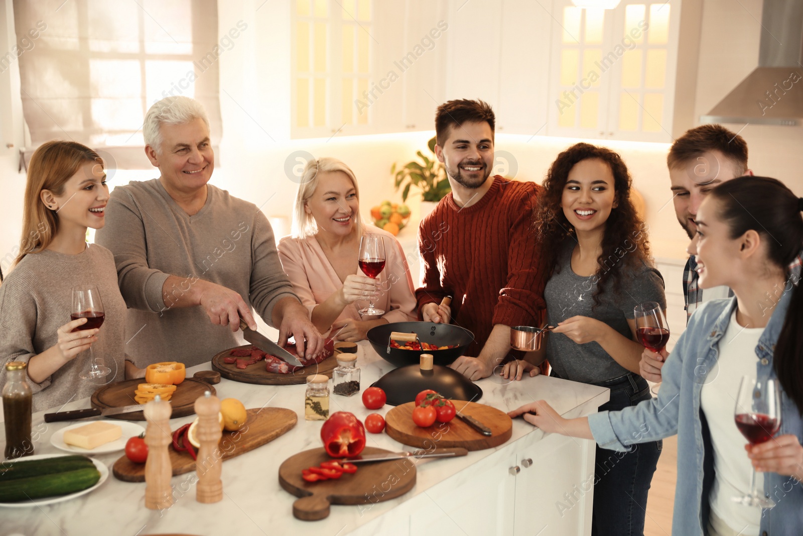 Photo of Happy people cooking food together in kitchen