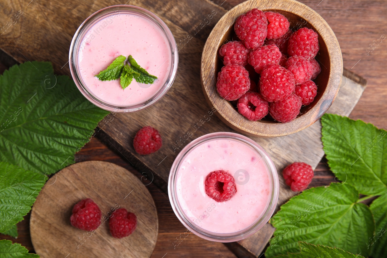 Photo of Tasty fresh raspberry smoothie on wooden table, flat lay