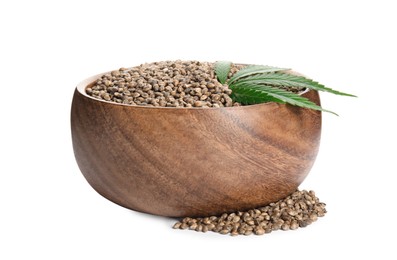 Wooden bowl with hemp seeds and leaf on white background