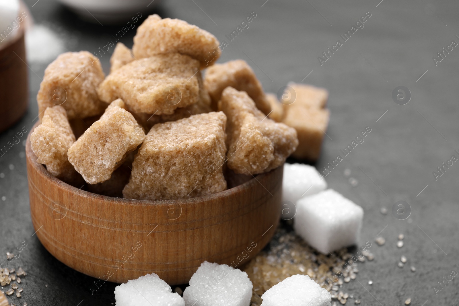 Photo of Different types of sugar on black table, closeup
