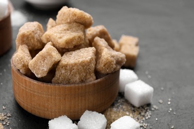 Different types of sugar on black table, closeup