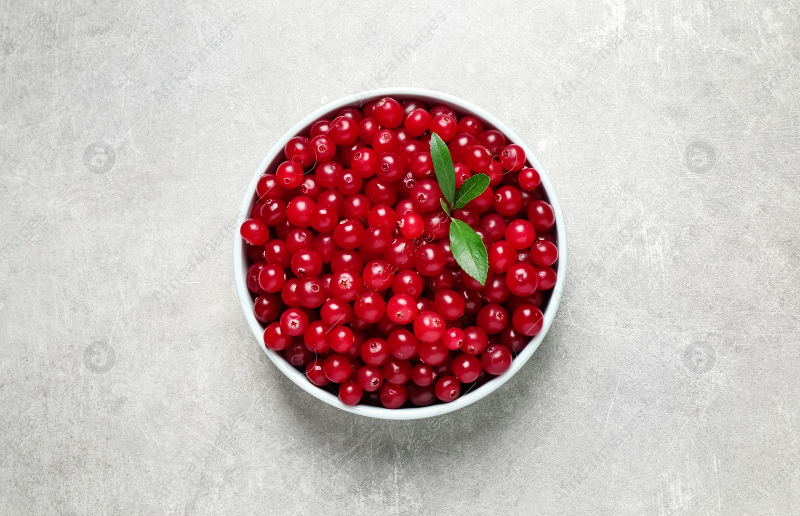 Photo of Tasty ripe cranberries on light grey table, top view