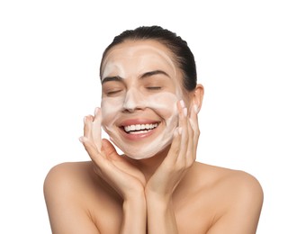 Happy young woman washing face with cosmetic product on white background