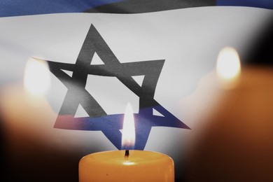 Image of Holocaust memory day. Double exposure with Flag of Israel and burning candles