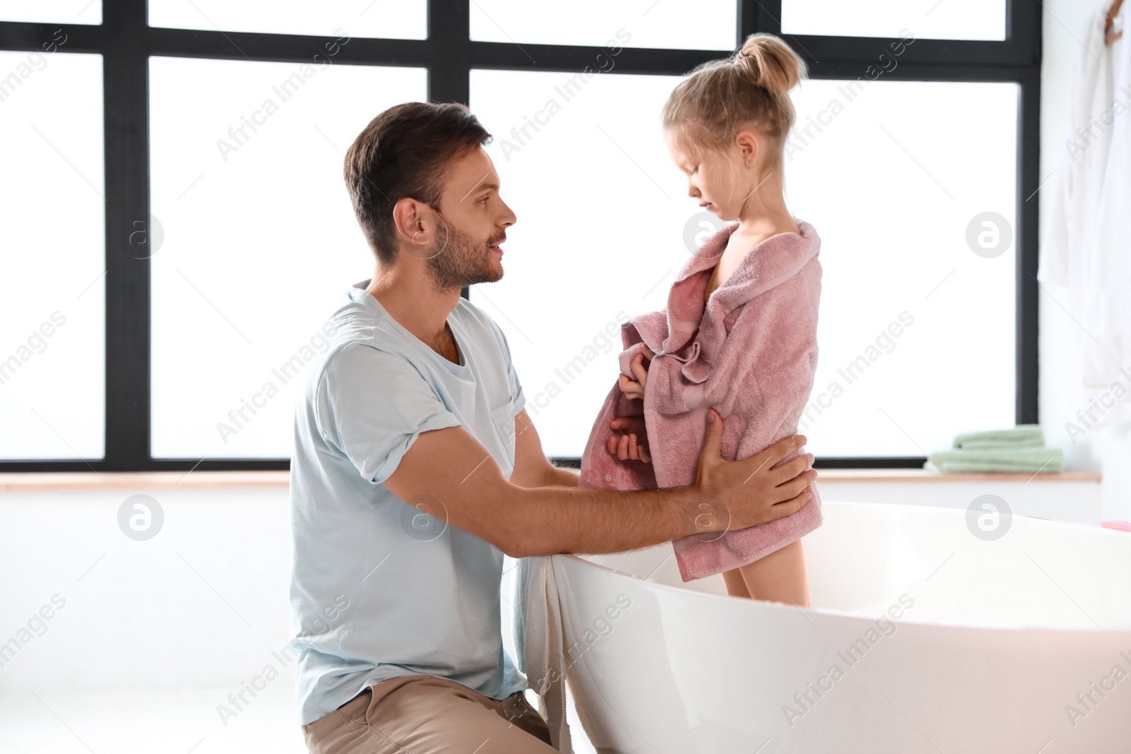 Photo of Father and his cute little daughter in bathroom