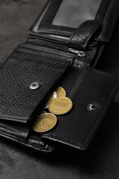 Photo of Poverty. Black wallet and coins on grey table, closeup