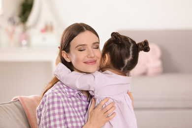 Young mother with little daughter at home