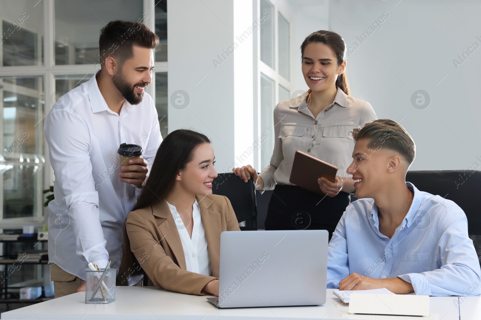 Photo of Colleagues working together in open plan office