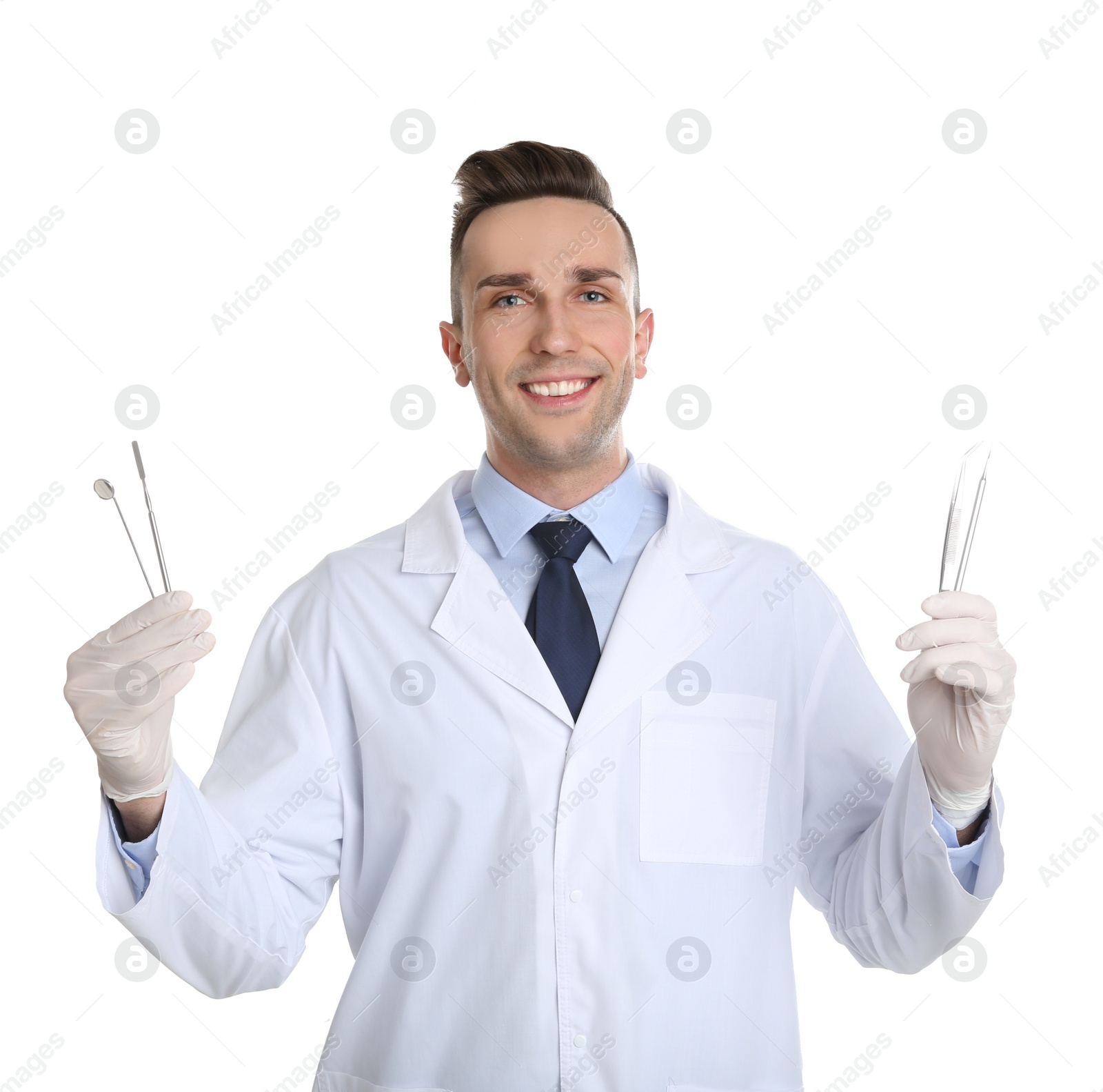 Photo of Male dentist holding professional tools on white background