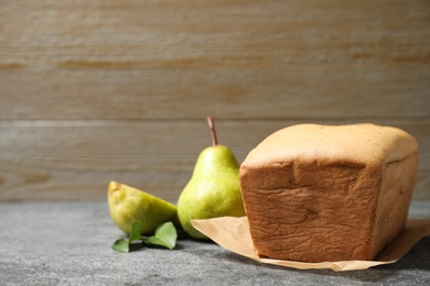 Photo of Tasty bread and pears on grey table. Homemade cake