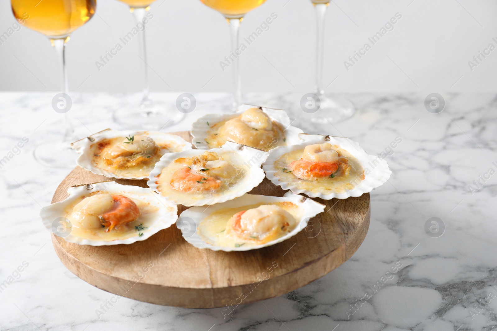 Photo of Fried scallops in shells on white marble table