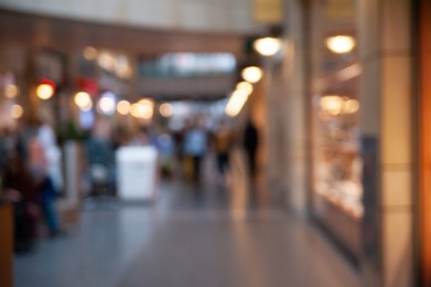 Blurred view of shopping mall with different stores, bokeh effect