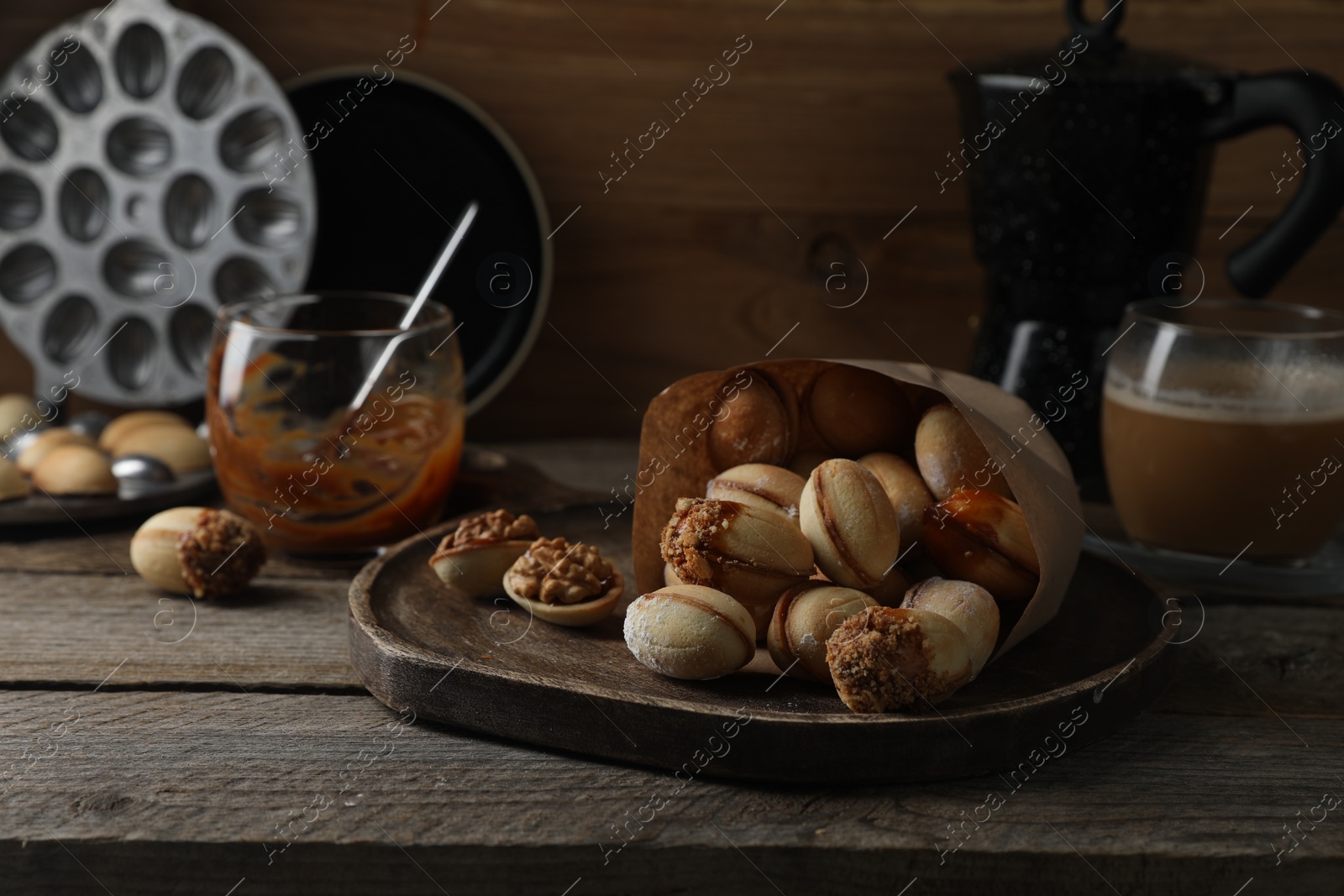 Photo of Freshly baked homemade walnut shaped cookies on wooden table, closeup. Space for text