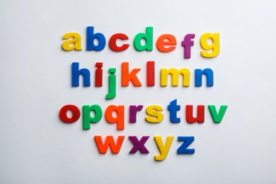 Photo of Plastic magnetic letters isolated on white, top view. Alphabetical order