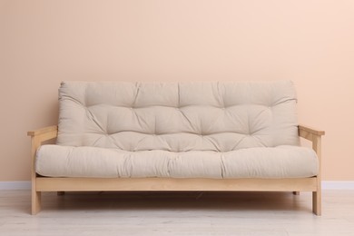 Photo of Comfortable sofa near beige wall on floor indoors