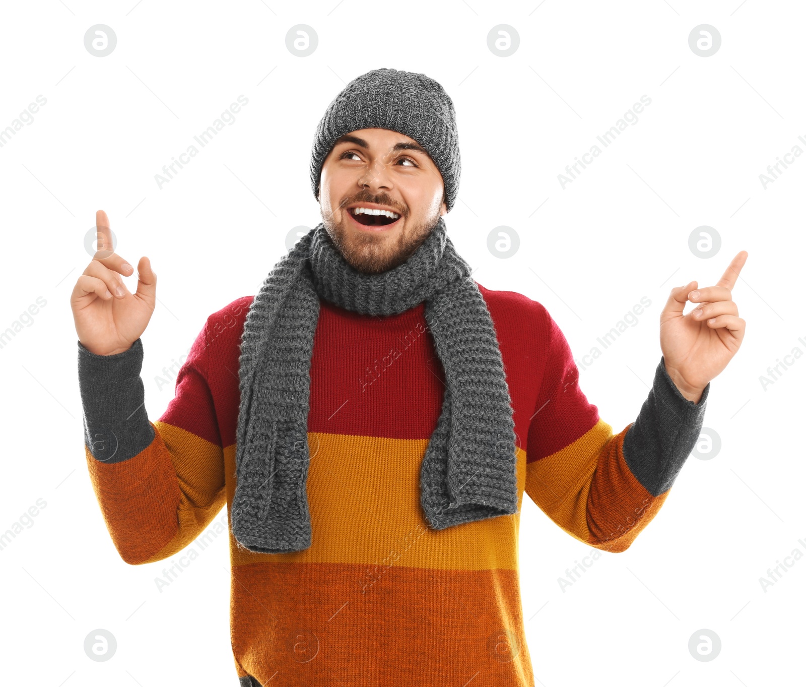 Photo of Emotional young man in warm clothes on white background. Winter vacation