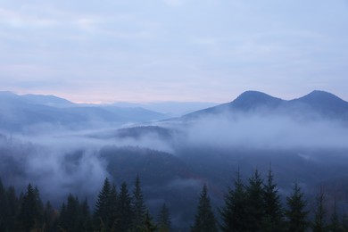 Photo of Beautiful view of mountains covered with fog during sunrise