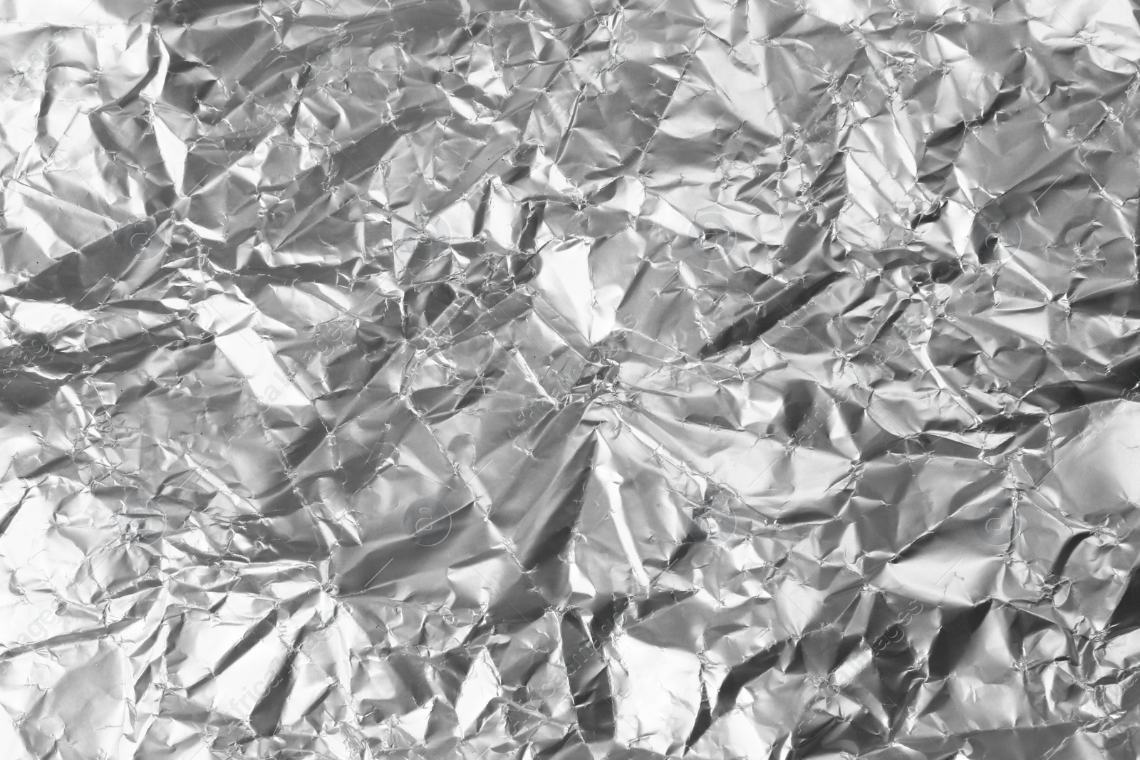 Photo of Crumpled silver foil as background, closeup view