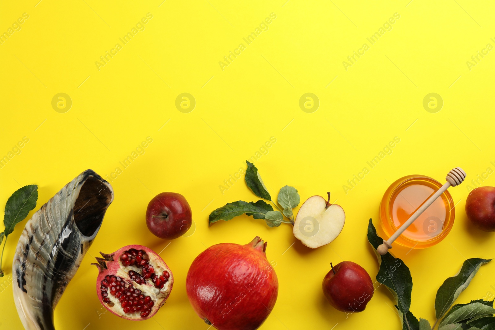 Photo of Flat lay composition with Rosh Hashanah holiday attributes on yellow background. Space for text