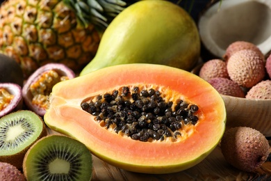 Photo of Fresh ripe papaya and other fruits on table, closeup