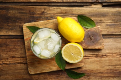 Photo of Cool freshly made lemonade and fruits on wooden table, flat lay