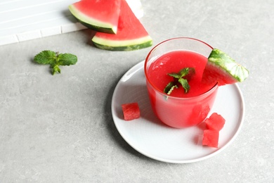 Photo of Summer watermelon drink with mint in glass served on table