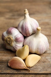 Photo of Fresh organic garlic on wooden table, closeup