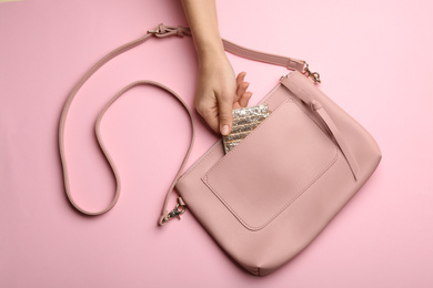 Photo of Woman with small bag on pink background, top view