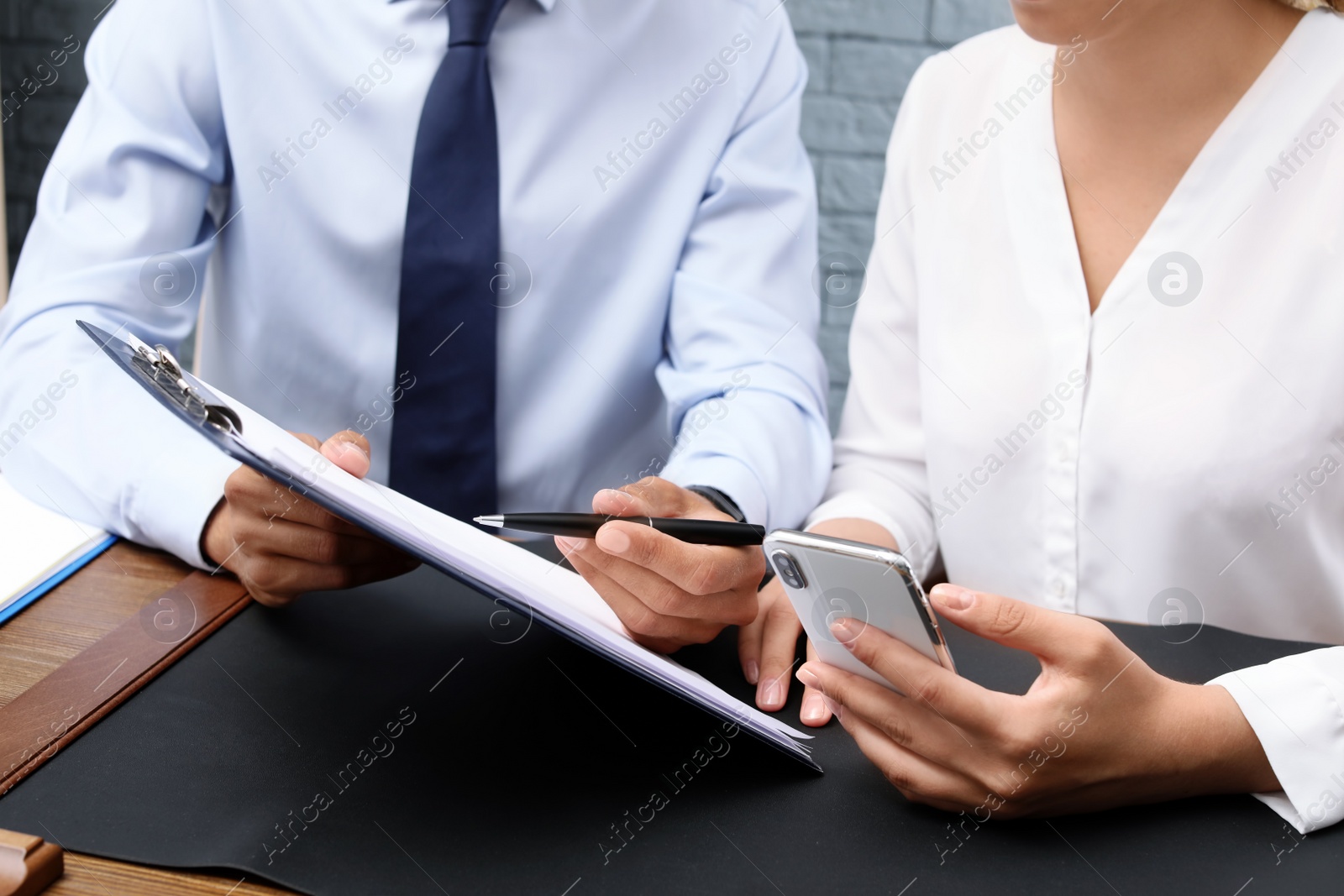 Photo of Lawyer working with client at table, closeup. Notary services