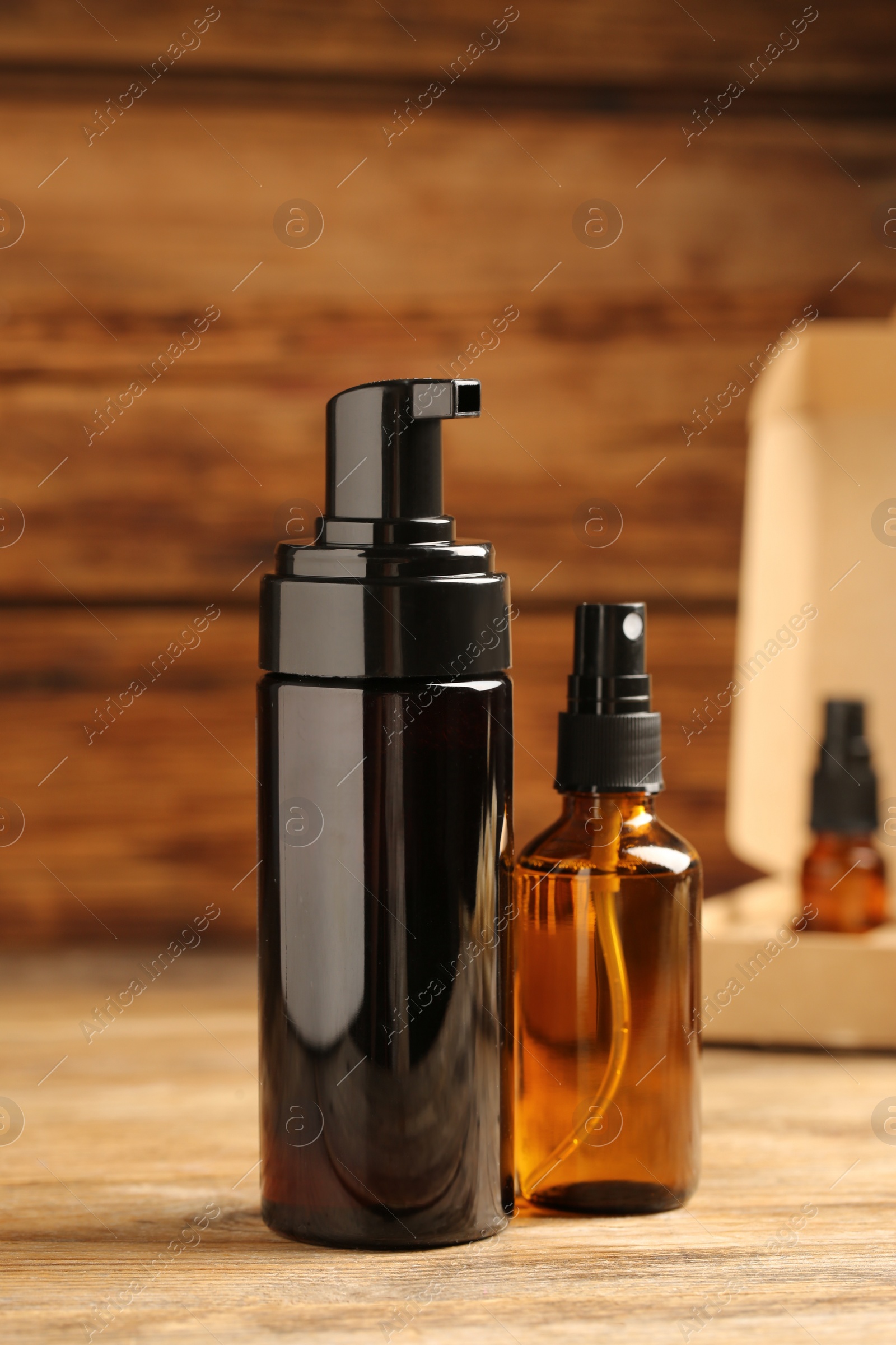 Photo of Bottles with oil on wooden table. Natural cosmetics