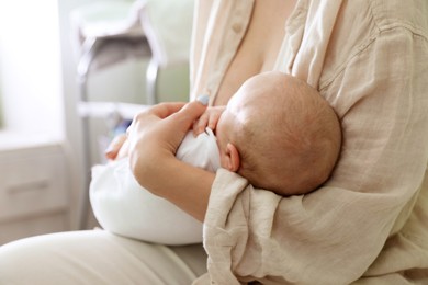 Mother holding her sleeping baby at home, closeup