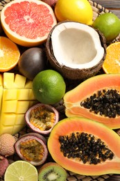 Photo of Fresh ripe papaya and other fruits on wicker mat, closeup view