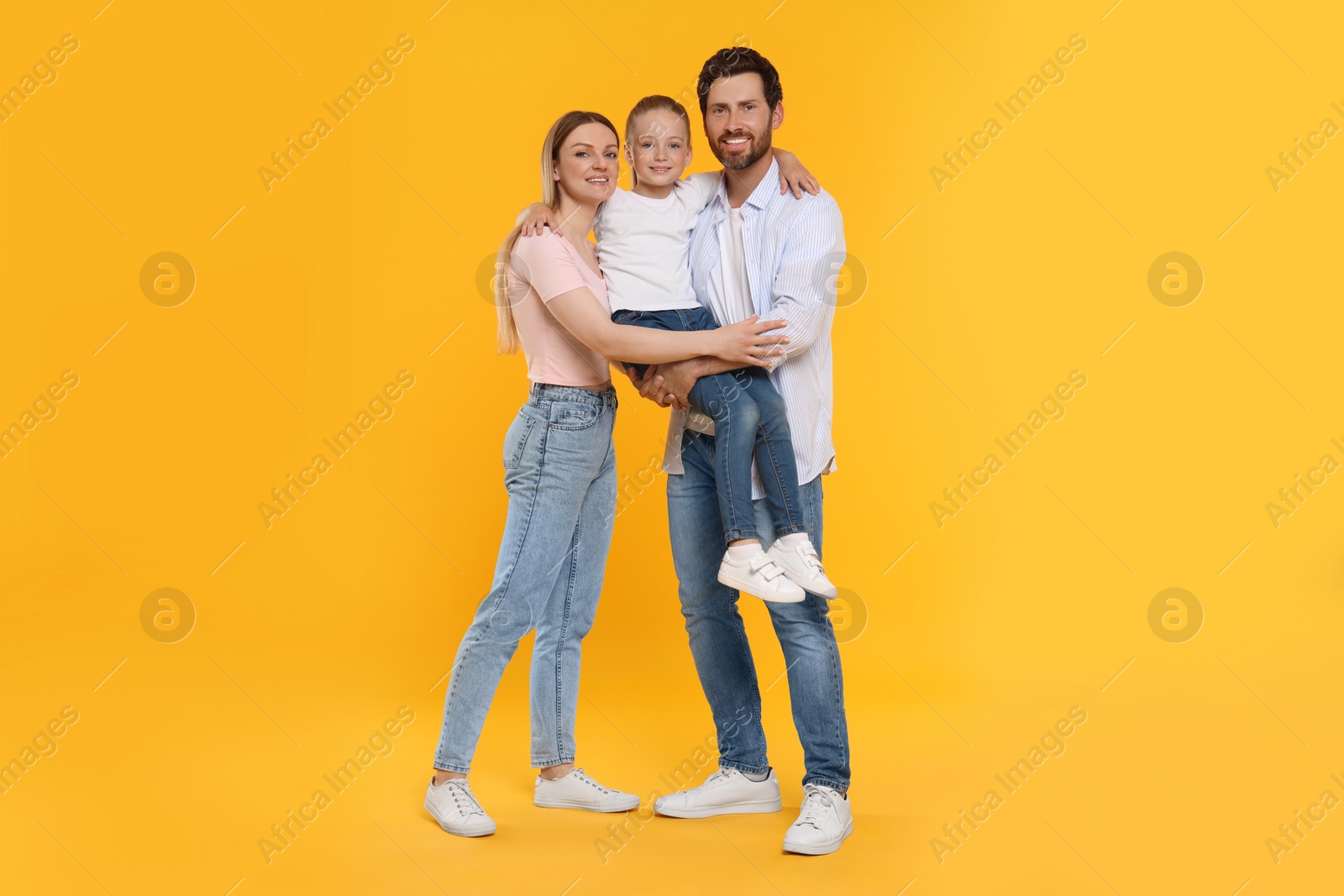 Photo of Portrait of happy family on orange background