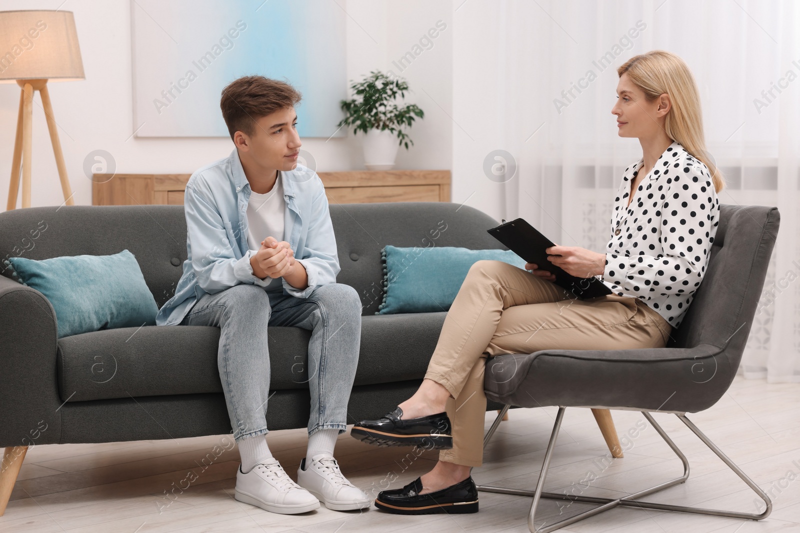 Photo of Psychologist working with teenage boy in office