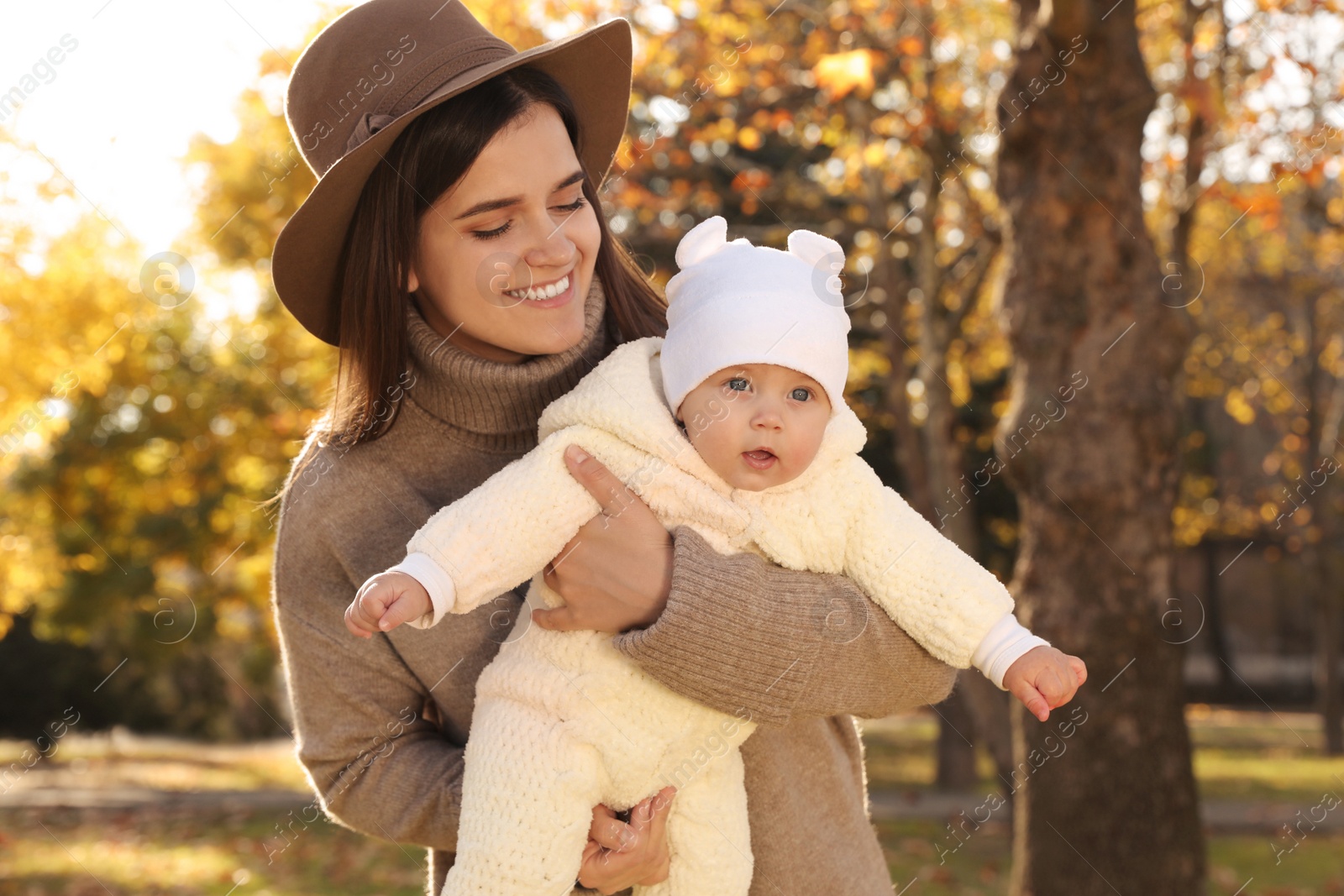 Photo of Happy mother with her baby daughter in park on sunny autumn day