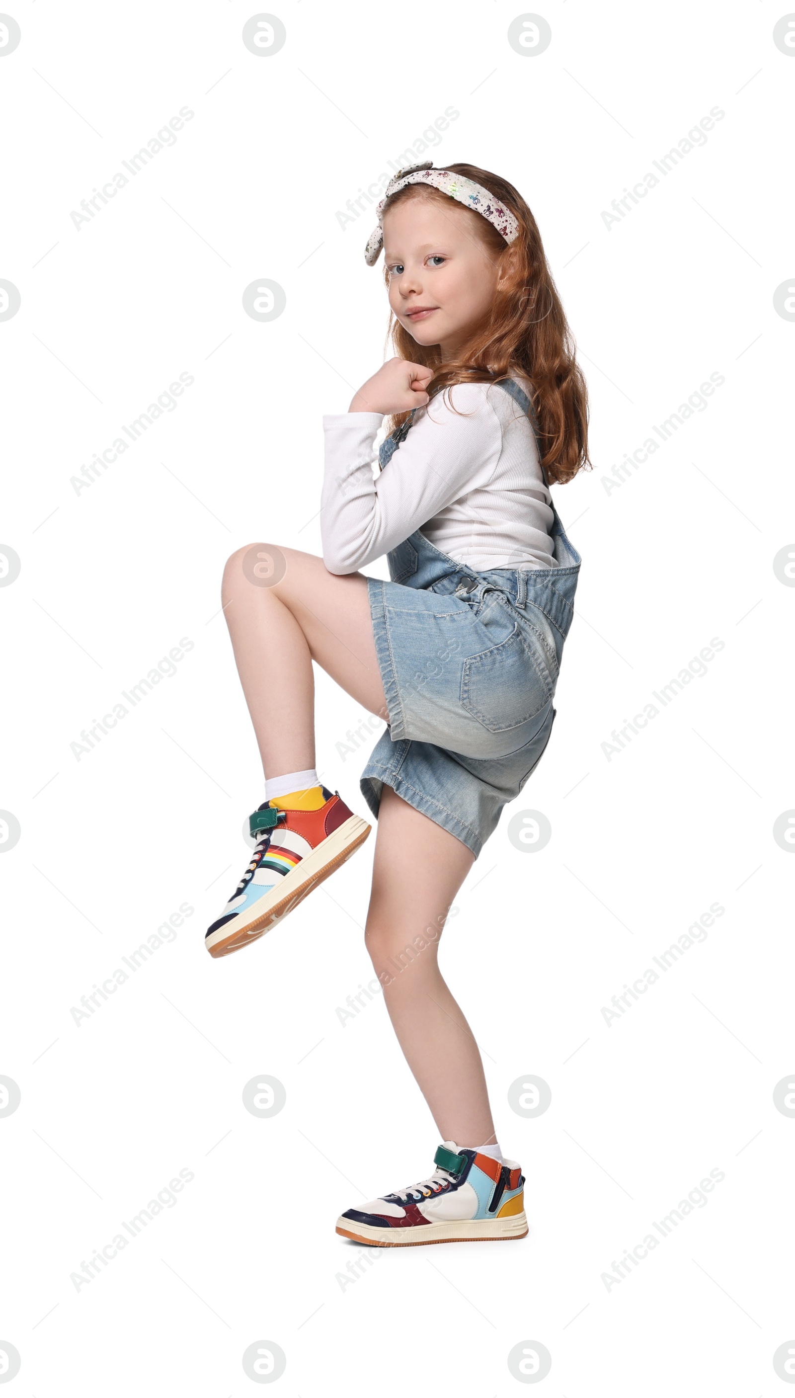 Photo of Cute little girl dancing on white background