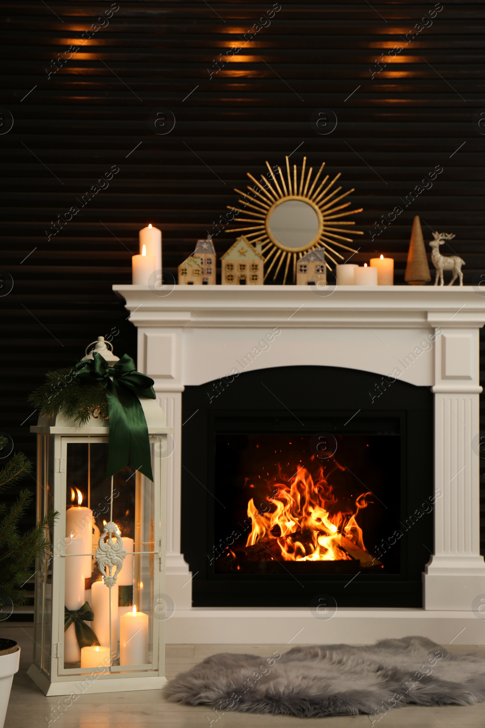 Photo of Beautiful Christmas lantern near fireplace in stylish room interior