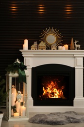 Beautiful Christmas lantern near fireplace in stylish room interior