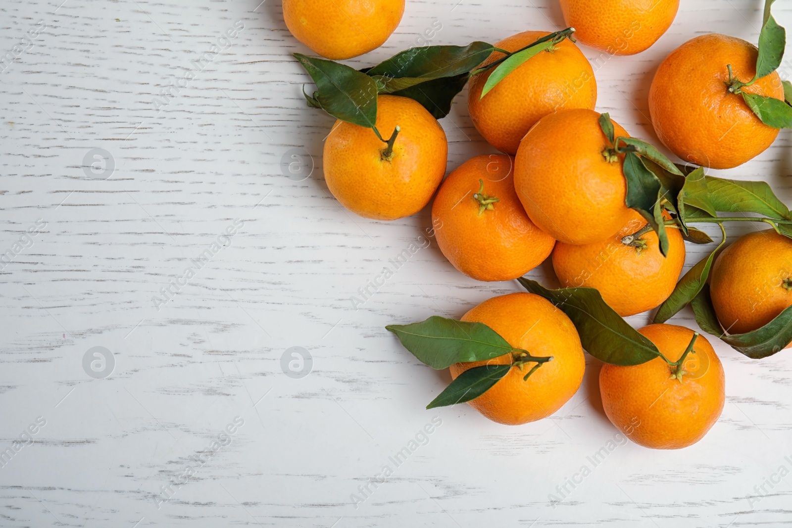 Photo of Fresh ripe tangerines and space for text on wooden background, top view