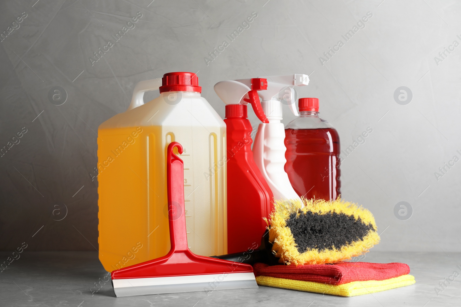 Photo of Car cleaning products and canister with motor oil on light grey table