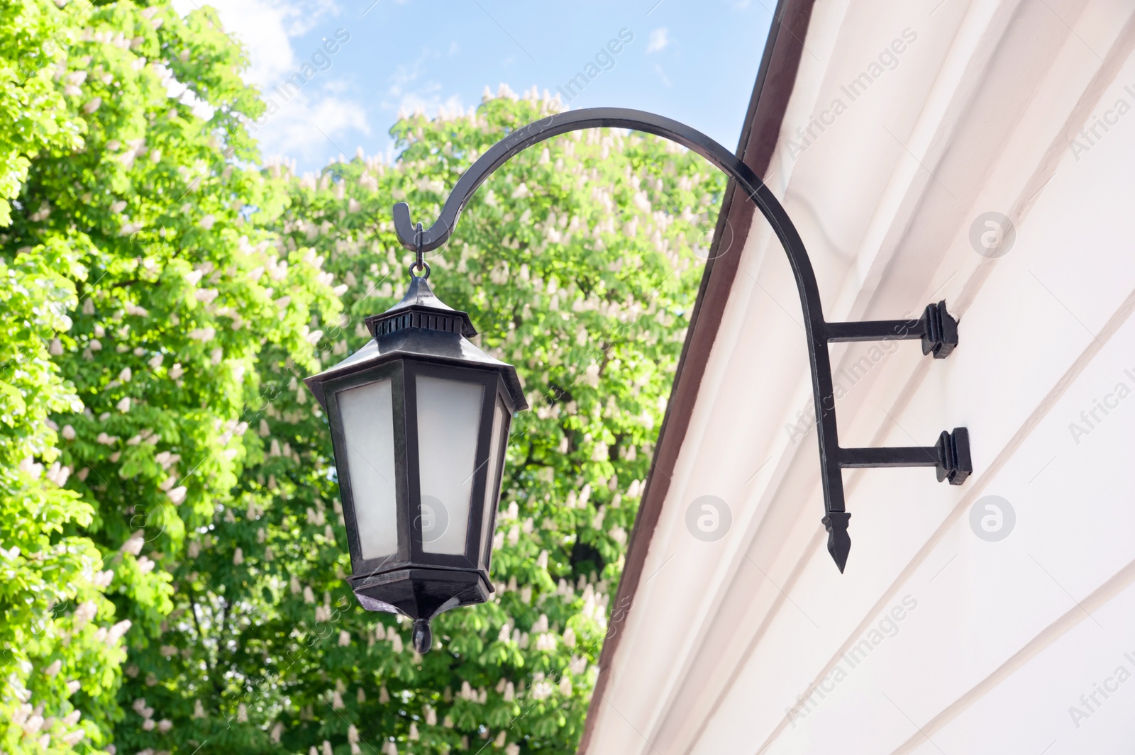 Photo of Vintage street lamp on wall of building outdoors, low angle view