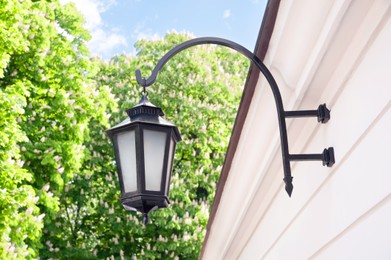 Photo of Vintage street lamp on wall of building outdoors, low angle view