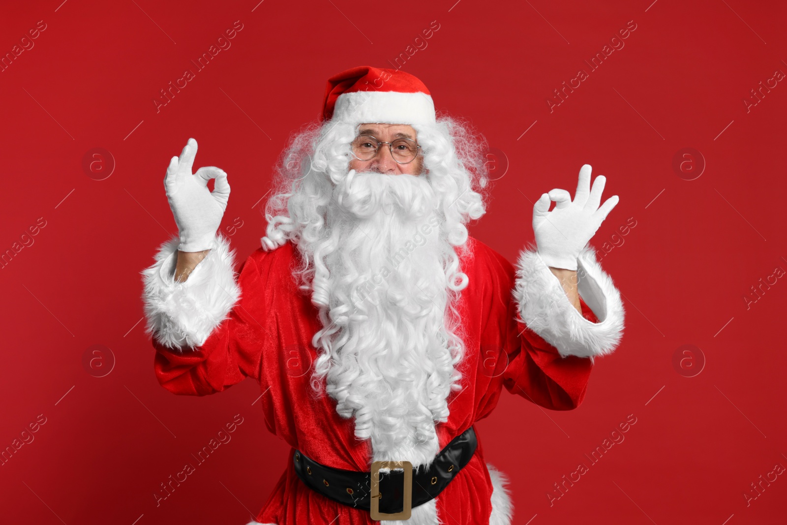 Photo of Merry Christmas. Santa Claus showing OK gestures on red background