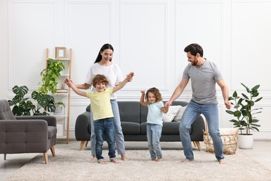 Photo of Happy family dancing and having fun in living room