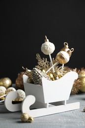 Delicious Christmas themed cake pops and festive decor on wooden table against black background