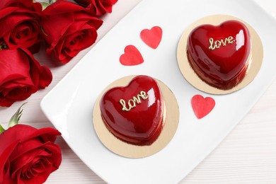 Photo of St. Valentine's Day. Delicious heart shaped cakes and roses on table, top view